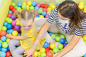 Toddler girl in child occupational therapy session doing playful exercises with her therapist during Covid-19 pandemic.