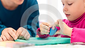 Toddler girl in child occupational therapy session doing sensory playful exercises with her therapist.