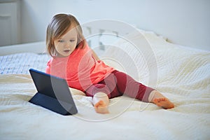 Toddler girl with digital tablet at home