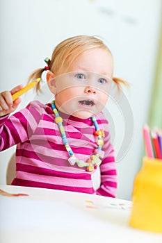 Toddler girl drawing with pencils