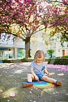 Toddler girl drawing rainbow with colorful chalks