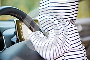 Toddler girl driving a modern car. baby with steering wheel