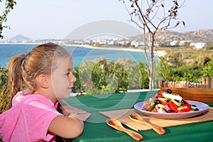 Toddler girl eating tradiotional Mediterranean salad