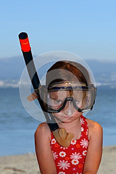 Toddler girl with father`s diving glasses and snorkel