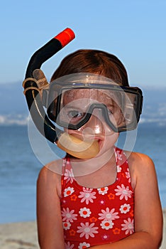 Toddler girl with father`s diving glasses and snorkel