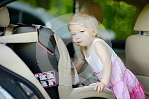 Toddler girl getting into a car seat