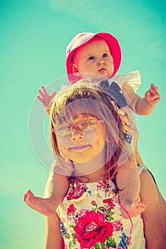 Toddler girl giving her little sister a piggyback