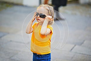 Toddler girl having fun on a street of medieval town of Quimper, Brittany, France. Happy child outdoors