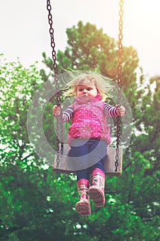 Toddler girl having fun on the swing