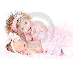 A toddler girl with her infant sister