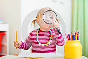 Toddler girl looking through magnifier