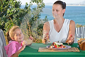 Toddler girl lunching tradiotional Mediterranean salad with her