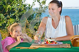 Toddler girl lunching tradiotional Mediterranean salad with her