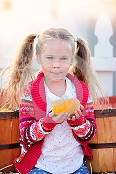 Toddler girl picking a pumpkin for Halloween