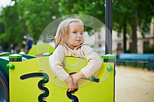 Toddler girl on playground slide. Outdoor activities for kids