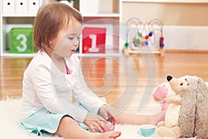 Toddler girl playing with her stuffed animals