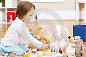 Toddler girl playing with her stuffed animals