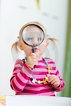 Toddler girl playing with magnifier