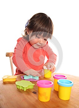 Toddler girl playing with play doh photo