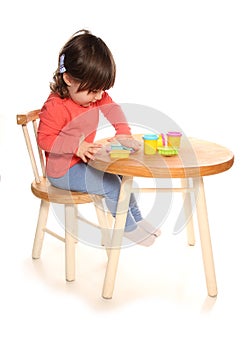 Toddler girl playing with play doh photo