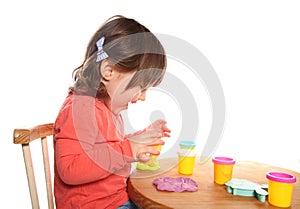 Toddler girl playing with play doh photo