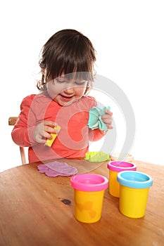 Toddler girl playing with play doh photo