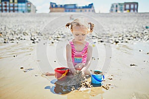 Toddler girl playing on the sand beach at Atlantic coast of Brittany, France