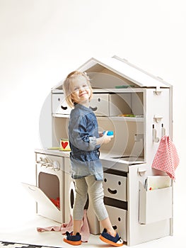 Toddler girl playing with toy kitchen at home