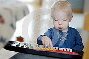 Toddler girl playing toy piano