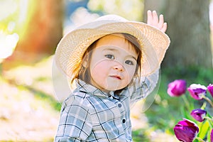 Toddler girl playing with tulips outside