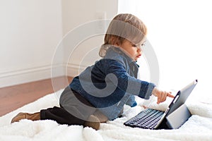 Toddler girl plays with iPad notebook