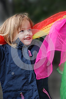 Toddler girl plays with silk scarfs