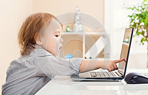 Toddler girl pointing to her laptop computer screen