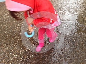 Toddler girl with umbrella outdoors at rainy day