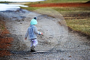 Toddler Girl on woodsy path looking down