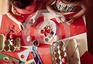 Toddler having fun painting Easter eggs.