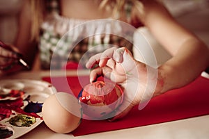 Toddler having fun painting Easter eggs.