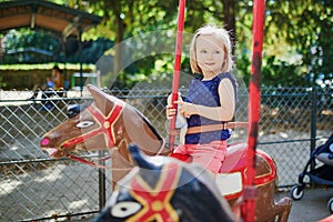 Toddler having fun on vintage French merry-go-round in Paris