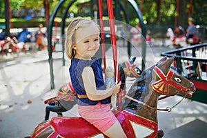 Toddler having fun on vintage French merry-go-round in Paris