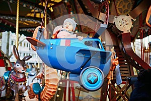 Toddler having fun on vintage French merry-go-round in Paris  France