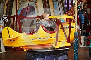 Toddler having fun on vintage French merry-go-round in Paris, France