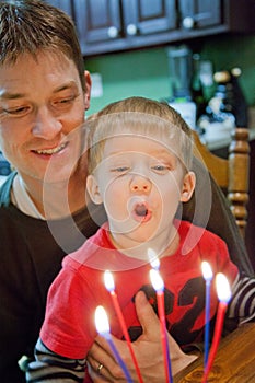 Toddler helping blow out Birthday candles