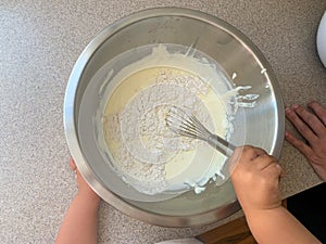 Toddler Helping Parents To Mix Batter