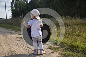 A toddler holds a reflector for the photographer. little helper assistant