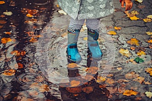 Toddler jumping in pool of water at the autumn day