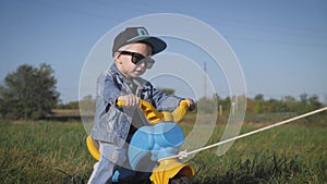 Toddler kid in funny glasses biking. Helping to ride a bike. Learning to ride a bike concept.
