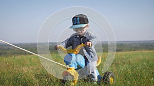 Toddler kid in funny glasses biking. Helping to ride a bike. Learning to ride a bike concept.