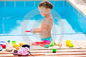 Toddler kid girl playing food toys in swimming pool