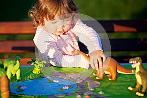 Toddler kid playing with a toy dinosaur.