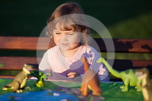 Toddler kid playing with a toy dinosaur.